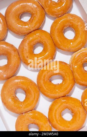 Vista dall'alto delle ciambelle smaltate in una scatola di consegna bianca Foto Stock