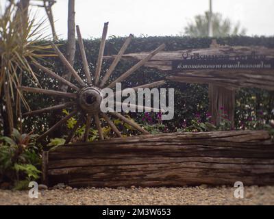 Una vecchia ruota di legno del carro è stata messa sul terreno. Foto Stock