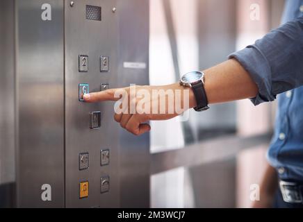 A quale piano si va? Primo piano di un uomo irriconoscibile che preme un pulsante in un ascensore. Foto Stock