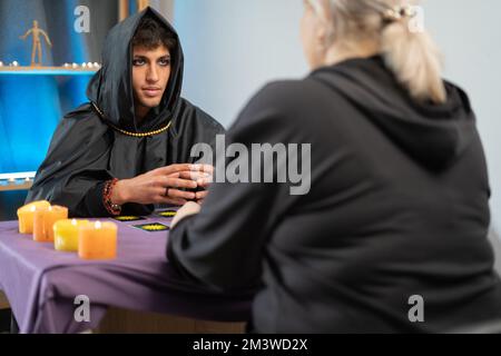 Carte Tarocchi. l'uomo del teller della fortuna che tiene un pacco delle schede del tarocco mentre le mischiano. Sessione mistica con il cliente Foto Stock