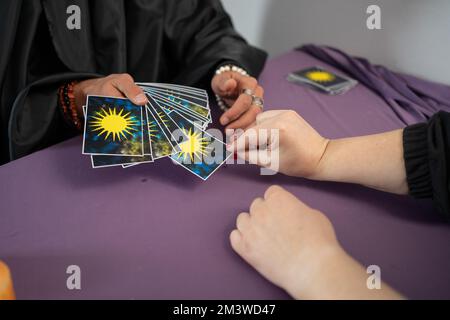 L'uomo sta leggendo le carte Tarocchi che trattano le carte per la donna in ufficio Foto Stock