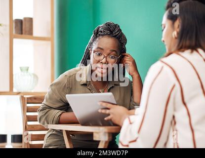 Social network reale vs social network online. due giovani donne che utilizzano uno smartphone insieme in un bar. Foto Stock