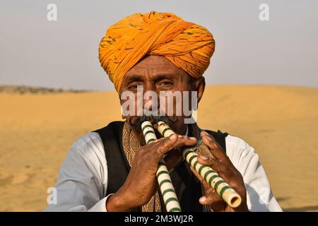 Jaisalmer Rajasthan, India 23rd gennaio 2020 durante il tramonto, quest'uomo stava suonando un pezzo di bella musica folk con due flauti insieme. Foto Stock