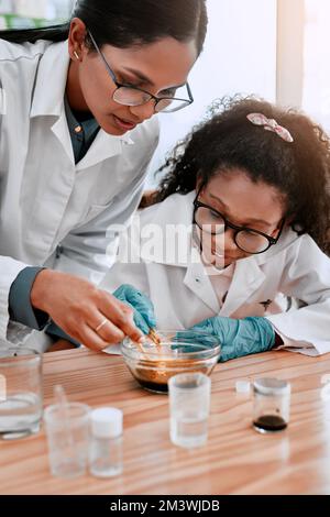 Lasciarli sperimentare fa parte dell'esperienza di apprendimento. una ragazza adorabile della scuola che fa un esperimento con la sua insegnante di scienza a scuola. Foto Stock