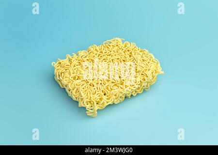 Spaghetti secchi istantanei sul tavolo blu. vista dall'alto Foto Stock