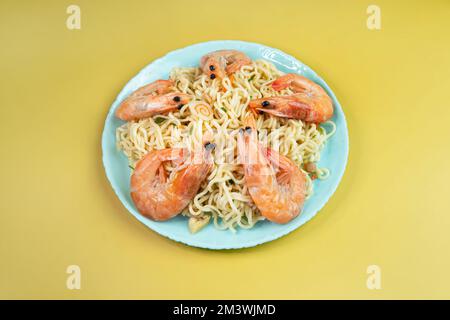 Instant Noodles su uno sfondo giallo con Shrimps Asian Thai cibo fusion stile facile piatto Street food popolare. vista dall'alto Foto Stock