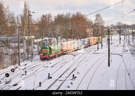 Riga, Lettonia - 8 dicembre, 2022: Breve treno merci su ferrovia innevata in inverno Foto Stock