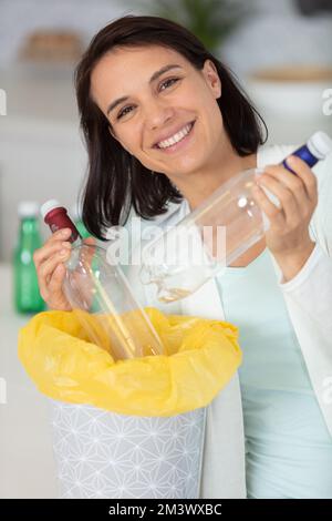 ragazza giovane che ordina bottiglie di plastica Foto Stock