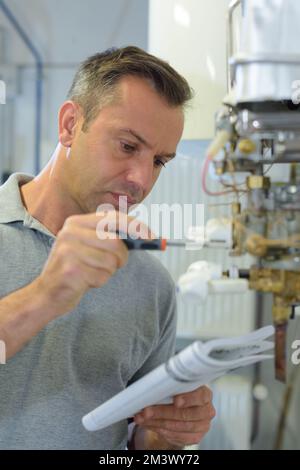 uomo che legge il manuale per la riparazione Foto Stock