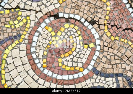 Vecchio mosaico incrinato attrae scienziati e l'attenzione turistica con durevolezza nel corso degli anni. Le cremagliere sul muro del mosaico della pietra hanno vicino significato storico Foto Stock