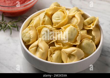 Ciotola con tortellini tradizionali italiani freschi ripieni di ricotta e spinaci da vicino Foto Stock