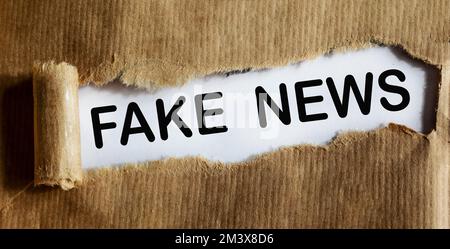 FALSA parola SCRITTA sotto carta strappata. Foto Stock