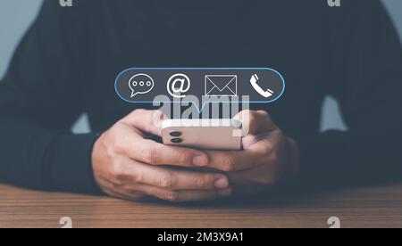Man Use smartphone contattaci o e-mail marketing concept, assistenza clienti hotline Contattaci People Connection. cubo di legno con la posta elettronica, telefono di chiamata Foto Stock