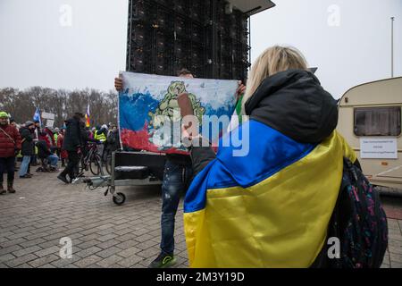 Il 17 dicembre 2022, i manifestanti si sono riuniti a Berlino alla porta di Brandeburgo per manifestare contro l'attuale governo tedesco. La protesta è stata organizzata sotto lo slogan "la Germania si alza, riaccende la democrazia”, e a cui hanno partecipato persone che esprimono il loro malcontento per l'attuale situazione politica del paese. I manifestanti hanno chiesto ai politici di assumersi la responsabilità delle loro azioni e hanno accusato il governo e l'Unione europea di essere guerrafondai. Alcuni manifestanti hanno espresso simpatia per la Russia e hanno portato bandiere russe, e uno stand con immagini di bambini affedeli Foto Stock