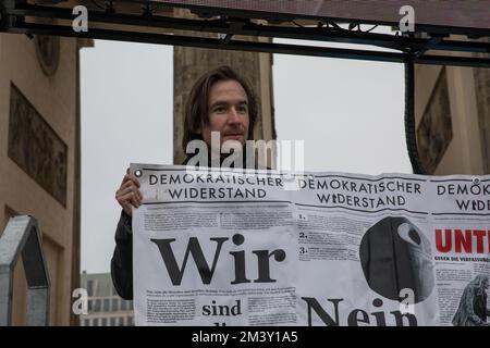 Il 17 dicembre 2022, i manifestanti si sono riuniti a Berlino alla porta di Brandeburgo per manifestare contro l'attuale governo tedesco. La protesta è stata organizzata sotto lo slogan "la Germania si alza, riaccende la democrazia”, e a cui hanno partecipato persone che esprimono il loro malcontento per l'attuale situazione politica del paese. I manifestanti hanno chiesto ai politici di assumersi la responsabilità delle loro azioni e hanno accusato il governo e l'Unione europea di essere guerrafondai. Alcuni manifestanti hanno espresso simpatia per la Russia e hanno portato bandiere russe, e uno stand con immagini di bambini affedeli Foto Stock