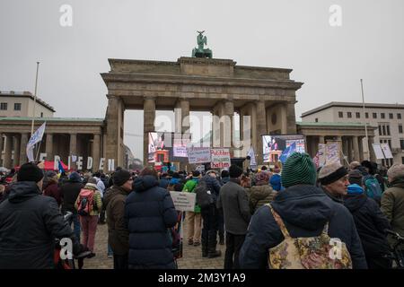 Il 17 dicembre 2022, i manifestanti si sono riuniti a Berlino alla porta di Brandeburgo per manifestare contro l'attuale governo tedesco. La protesta è stata organizzata sotto lo slogan "la Germania si alza, riaccende la democrazia”, e a cui hanno partecipato persone che esprimono il loro malcontento per l'attuale situazione politica del paese. I manifestanti hanno chiesto ai politici di assumersi la responsabilità delle loro azioni e hanno accusato il governo e l'Unione europea di essere guerrafondai. Alcuni manifestanti hanno espresso simpatia per la Russia e hanno portato bandiere russe, e uno stand con immagini di bambini affedeli Foto Stock