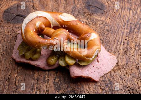 polpettone a fette in un pretzel su legno Foto Stock