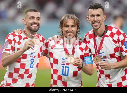 Mateo Kovacic (a sinistra) della Croazia, Luka Modric (al centro) e Ivan Perisic con le loro medaglie di bronzo dopo la partita di calcio del terzo posto della Coppa del mondo FIFA allo stadio internazionale Khalifa di Doha. Data immagine: Sabato 17 dicembre 2022. Foto Stock