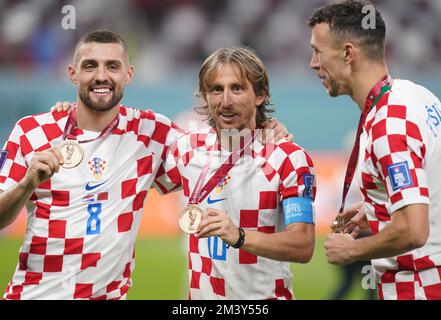 Mateo Kovacic (a sinistra) della Croazia, Luka Modric (al centro) e Ivan Perisic con le loro medaglie di bronzo dopo la partita di calcio del terzo posto della Coppa del mondo FIFA allo stadio internazionale Khalifa di Doha. Data immagine: Sabato 17 dicembre 2022. Foto Stock