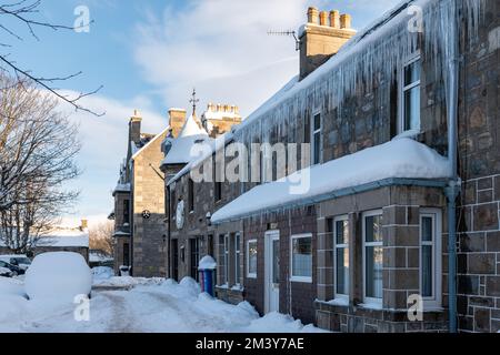 Tomintoul, Moray, Regno Unito. 17th Dec, 2022. Si tratta di scene all'interno del villaggio molto vinicolo di Tomintoul. Dopo le tempeste di neve è diventato molto freddo con tutto il congelamento e la formazione di ciclicini come si può vedere sul tetto della casa e dei locali del negozio. Credit: JASPERIMAGE/Alamy Live News Foto Stock