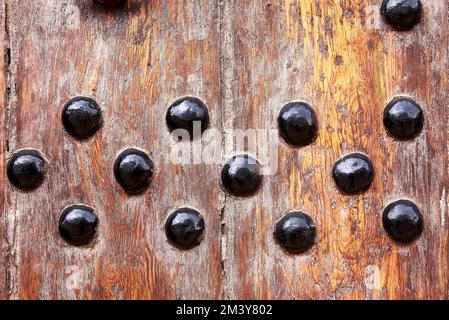 Chiodi grandi a testa tonda in tavole di legno. Porta, artigianato, antiquariato, fatto a mano, vista frontale. legno stagionato Foto Stock