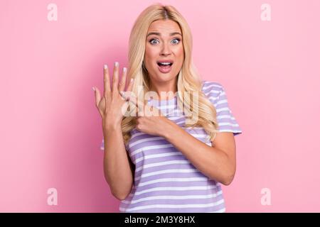 Foto di insoddisfatto bella signora bionda capelli bride dito punto indicare problema nessun anello guardare fotocamera isolato su sfondo colore rosa pastello Foto Stock