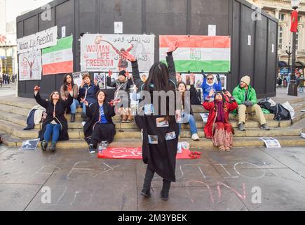 Londra, Regno Unito. 17th dicembre 2022. Un manifestante esegue una danza con un cappio attorno al collo e immagini di manifestanti incarcerati in Iran sul suo cappotto. Un gruppo di donne ha organizzato una manifestazione e una performance a Piccadilly Circus per protestare contro le esecuzioni di manifestanti anti anti anti-governativi in Iran. Gli attivisti legarono le corde intorno al collo e coprì le mani in sangue falso. Credit: Vuk Valcic/Alamy Live News Foto Stock