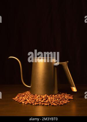 Una foto verticale di un bollitore a collo d'oca sui chicchi di caffè Foto Stock