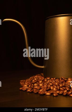 Una foto verticale di un bollitore a collo d'oca sui chicchi di caffè Foto Stock