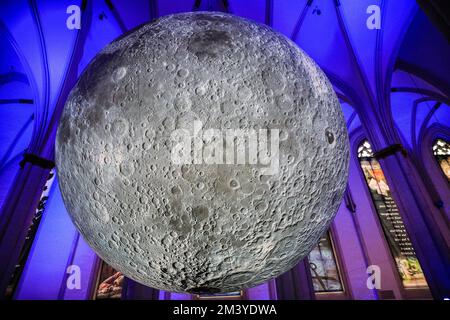 Münster, Germania. 17th Dec, 2022. La gente visita l'installazione illuminata del "Museo della Luna" di 7 metri di diametro dell'artista britannico Luke Jerram a Überwasserkirche, una chiesa gotica nel centro della città vecchia di Münster. Le code si sono formate fuori dalla chiesa e l'installazione si rivela chiaramente popolare tra i molti visitatori della città storica. Credit: Imageplotter/Alamy Live News Foto Stock