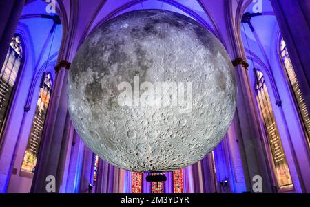 Münster, Germania. 17th Dec, 2022. La gente visita l'installazione illuminata del "Museo della Luna" di 7 metri di diametro dell'artista britannico Luke Jerram a Überwasserkirche, una chiesa gotica nel centro della città vecchia di Münster. Le code si sono formate fuori dalla chiesa e l'installazione si rivela chiaramente popolare tra i molti visitatori della città storica. Credit: Imageplotter/Alamy Live News Foto Stock