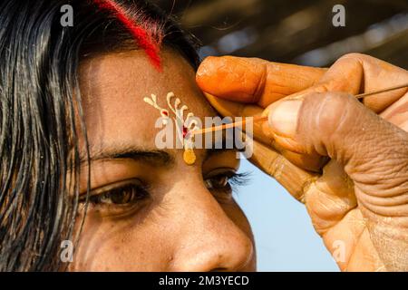 Sacerdote applicare un Tilak sulla fronte di un pellegrino a Sangam, la confluenza dei fiumi santi Ganges, Yamuna e Saraswati Foto Stock