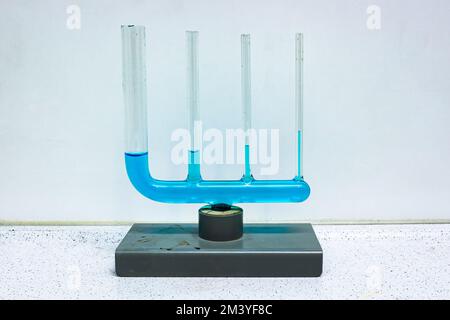 Apparecchiature in vetro in cui diversi tubi collegati sono riempiti con un liquido blu, a dimostrazione dell'azione capillare. Utilizzato nella classe fisica. Foto Stock