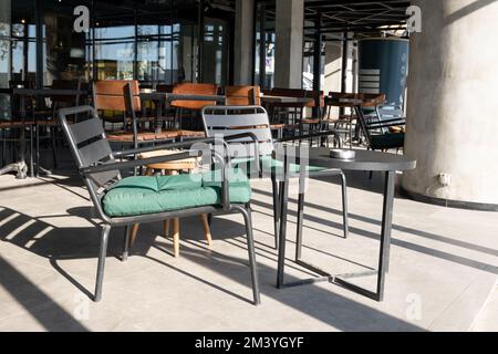 Sedie e tavoli di metallo vuoti davanti al caffè. Due sedie metalliche vuote e un tavolo Foto Stock