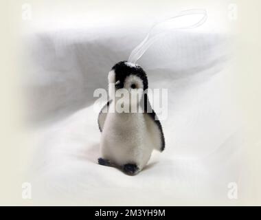 Fotografia di un piccolo pinguino decorato di Natale. 2022.Configurazione di Studio su sfondo chiaro Foto Stock
