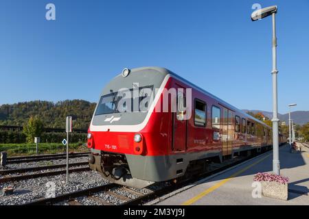 Kamnik, Slovenia - 18 ottobre 2022: Treno passeggeri per pendolari moderno rosso in ambiente rurale. Il tedesco sloveno fece un treno passeggeri in una giornata di sole Foto Stock