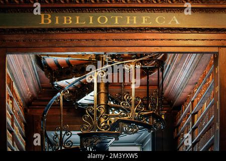 Lettering Bibliotheca sulla cornice della porta, vecchia biblioteca del 18th ° secolo, librerie e scala a chiocciola nella Sala lunga, dettaglio, illustrazione Foto Stock