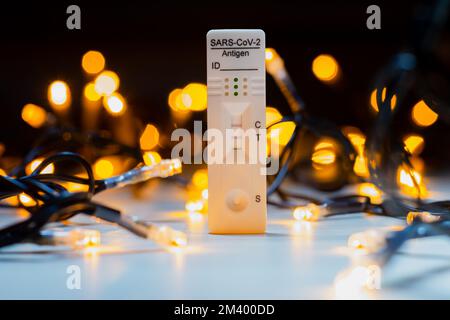 Test corona positivo con luci natalizie sullo sfondo Foto Stock