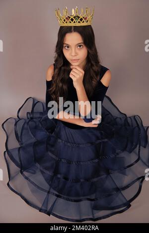 Ragazza egoista adolescente in abito palla celebra la vittoria di successo. Bambino  adolescente in corona regina isolato su sfondo grigio. Principessa ragazza  in tiara. PROM Foto stock - Alamy