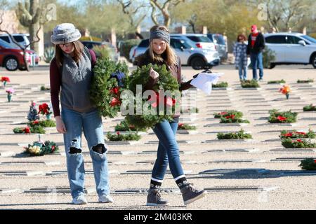 Due donne cercano una pietra miliare particolare durante le corone annuali in tutta l'America, che prevede corone di festa per onorare e ricordare i veterani e i nostri eroi caduti countryÕs al National Memorial Cemetery di Phoenix, Arizona USA il 17 dicembre 2022. Le corone in tutta l'America coordinano le cerimonie di posa della corona in più di 3.000 località negli Stati Uniti e all'estero alla stessa data e ora in tutte le località per coordinarsi con quella al cimitero nazionale di Arlington. (Foto di: Alexandra Buxbaum/Sipa USA) Credit: Sipa USA/Alamy Live News Foto Stock