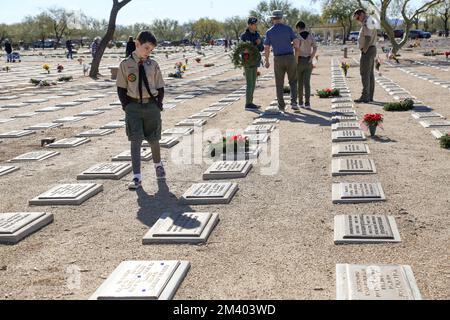 Una Boy Scout cerca una particolare pietra miliare durante le corone annuali in tutta l'America, che prevede corone natalizie per onorare e ricordare i veterani e gli eroi caduti del nostro paese al National Memorial Cemetery di Phoenix, Arizona USA il 17 dicembre 2022. Le corone in tutta l'America coordinano le cerimonie di posa della corona in più di 3.000 località negli Stati Uniti e all'estero alla stessa data e ora in tutte le località per coordinarsi con quella al cimitero nazionale di Arlington. (Foto di: Alexandra Buxbaum/Sipa USA) Credit: Sipa USA/Alamy Live News Foto Stock