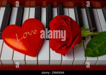 Love Shaped Heart e Red Rose su piano Keys Still Life Foto Stock