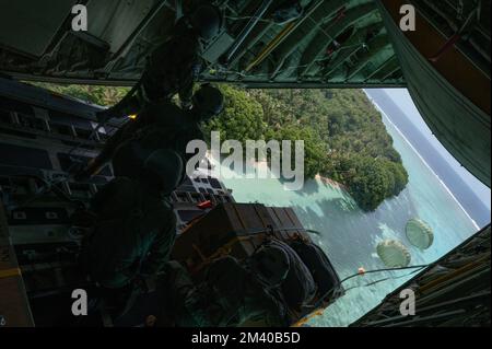 Sapwuahfik, Stati federati della Micronesia. 07 dicembre 2022. L'Airman dell'aeronautica degli Stati Uniti e del Giappone lascia un pacco fuori dalla rampa di un velivolo JASDF C-130H Hercules durante l'operazione Christmas Drop 2022, 7 dicembre 2022 a Sapwuahfik, Raven Islands, FSM. Operazione Christmas Drop è la più antica missione umanitaria e di soccorso in caso di disastri che offre 71.000 chili di cibo, regali e forniture per assistere le comunità remote dell'isola nel Pacifico meridionale. Credito: SSgt. Jerreht Harris/US Airforce Photo/Alamy Live News Foto Stock