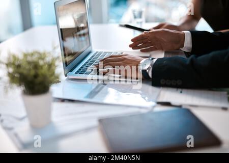 Dobbiamo davvero andare al di sopra di questo aspetto. un uomo d'affari irriconoscibile seduto con la sua collega femminile in ufficio e a digitare sul suo computer portatile. Foto Stock