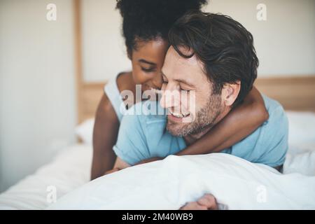 Il loro è un matrimonio felice. una giovane coppia affettuosa che condivide un momento intimo mentre si rilassa sul proprio letto a casa. Foto Stock