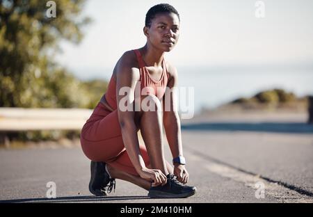 Scarpe in pizzo, fitness e donna nera in strada per allenarsi, correre e benessere in Nigeria. Scarpe da runner, atleta sportiva e ragazza con cravatta per Foto Stock