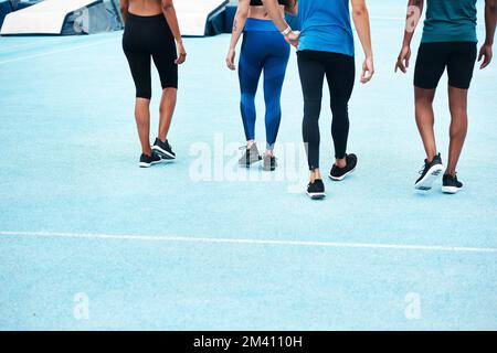 Il fitness è la nostra abitudine preferita. un gruppo irriconoscibile di atleti che camminano insieme dopo una corsa in pista. Foto Stock