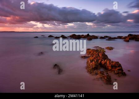 Un paesaggio delle Snapper Rocks sotto il colorato cielo crepuscolo al tramonto a Coolangatta, Australia Foto Stock