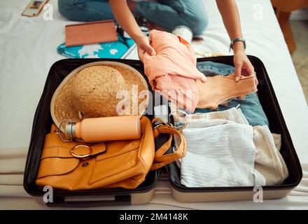 Mani, donna e valigia su un letto per viaggi, avventure e vacanze estive, imballaggio e abbigliamento. Mano, ragazza e bagagli in una camera da letto per viaggiare Foto Stock