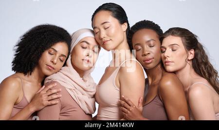 Viso, bellezza e gruppo di donne con gli occhi chiusi in studio isolato su sfondo grigio. Diversità, cosmetici per la cura della pelle o trucco di ragazze, donne Foto Stock